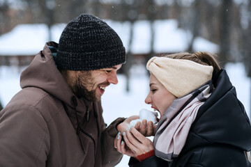 Valentines day outdoors celebration date ideas. Winter love story. Cold season dating for couples. Young couple in love play snowball, hugging and kissing in winter city street and park
