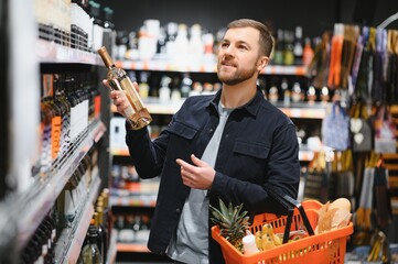 Man in a supermarket choosing a wine