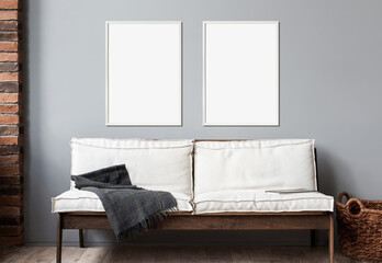 Blank picture frame mockup on gray wall. Modern living room design. View of modern scandinavian rustic style interior with sofa. Two vertical templates for artwork, painting, photo or poster