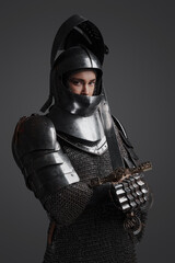 Naklejka premium Isolated on grey background female knight from past with chainmail and sword.