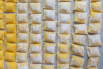 Making square ravioli, homemade pasta with a filling, enveloped in thin pasta dough. Raw italian food.