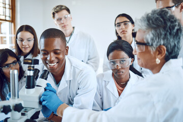 Education, science and teacher with students using microscope for chemistry, biology and medical...