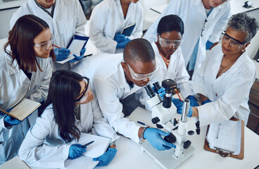 Student, microscope and science in university class, group and learning with woman lecturer,...