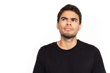 Confused young man looking away at ads. Portrait of pensive Caucasian male model with short dark hair in black T-shirt frowning, thinking or seeing something strange. Confusion, advertising concept