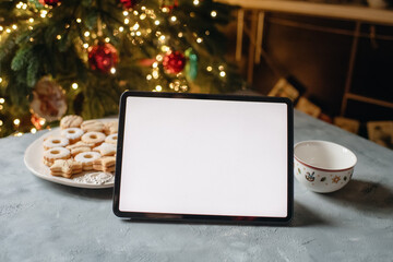 laptop on the background of a Christmas tree, online work on holidays, mockup device
