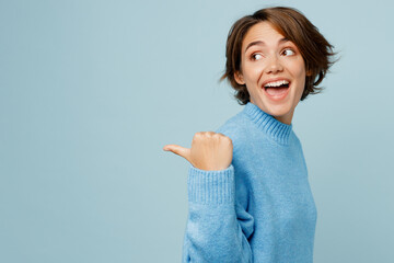 Young woman wear knitted sweater point thumb finger aside indicate on workspace area copy space...