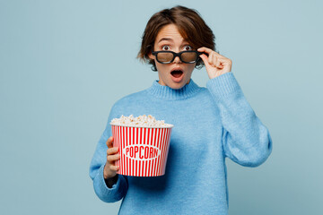 Young scared astonished surprised pop-eyed woman lower 3d glasses watch movie film holding bucket...