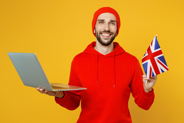 Young translator smiling hapy fun smart IT man wear red hoody hat use work on laptop pc computer...