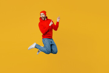 Fototapeta na wymiar Full body young caucasian man wear red hoody hat look camera jump high point index finger aside indicate on workspace area copy space mock up isolated on plain yellow color background studio portrait.