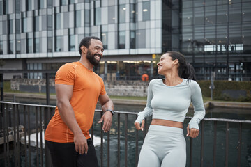Fitness, running and couple of friends happy in the city ready for sports, workout and exercise. Runner, training and smile of athlete people together on a break for wellness, health and happiness