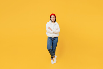 Fototapeta na wymiar Full body young woman of African American ethnicity wear white padded windbreaker jacket red hat hold hands crossed folded isolated on plain yellow background studio portrait People lifestyle concept.