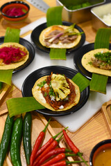 Tacos on a wooden table with vegetables