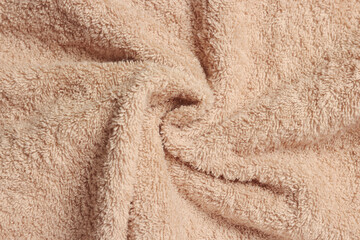 Fototapeta na wymiar Soft crumpled beige towel as background, top view