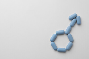 Male sign made of pills and space for text on white background, top view. Potency problem