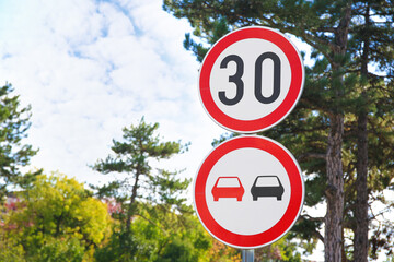 Post with road signs Maximum Speed 30 and No Overtaking outdoors. Space for text