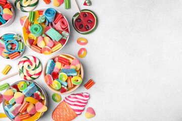 Many tasty colorful jelly candies on white table, flat lay. Space for text