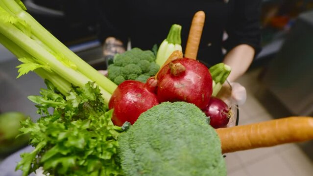 In the kitchen of a vegetarian restaurant. Cook with raw vegetables in his hands. Ingredients