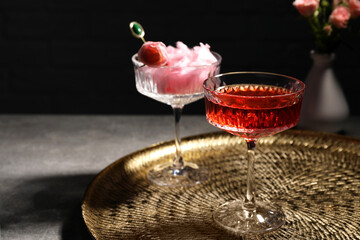 Glasses with rose wine and cotton candy on grey table