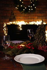 Plates, glasses and festive decor on wooden table