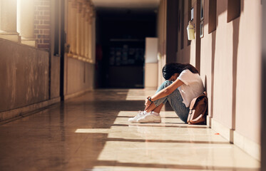 Sad, lonely and girl with depression at school, crying and anxiety after bullying. Mental health, tired and unhappy student in the corridor after problem in class, education fail and social isolation - obrazy, fototapety, plakaty