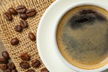 Cup of aromatic coffee on wooden table, top view. Space for text