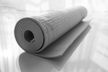 Rolled karemat or fitness mat on floor indoors, closeup