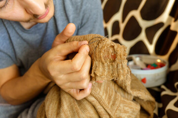 Mending clothes. Concept of mending and repairing clothes. Creative sustainable fashion and recycling.