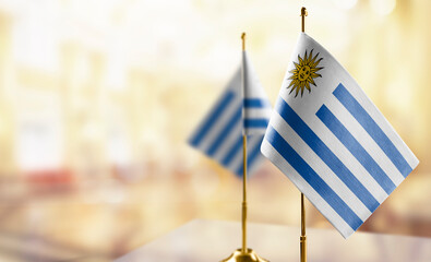 Small flags of the Uruguay on an abstract blurry background