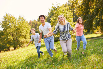 Familie mit zwei Kindern beim Laufen im Park - obrazy, fototapety, plakaty