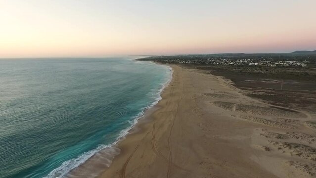 Aerial top view of the Atlantic coast of Spain in Cadiz as the waves meet the beach on a late evening