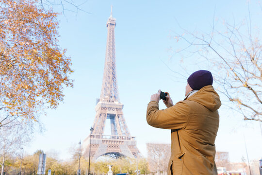 Man takes pictures of Eiffel Tower in Paris, winter season December