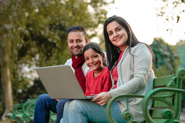 Indian family using laptop at park