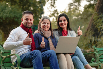 Fototapeta na wymiar Indian people using laptop and showing thumps up at park