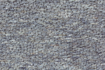 Gray wall made of small stones. Natural background.
