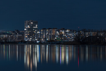 Obraz na płótnie Canvas Scenic view of the city of Dnepr in the winter evening. Dnipro in the evening. Ukrainian city in winter at night. background image. Panoramic view. Long exposure photo of the Dnieper River at night.