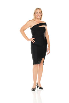 Middle aged smiling senior woman in black tight dress posing on a white background