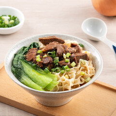 Beef noodle soup. Taiwanese famous food in a bowl on wooden table.