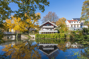 Fototapeta na wymiar Brentanohaus an der Nidda in Rödelheim im Brentanopark in Frankfurt am Main mit herbstlichen Bäumen