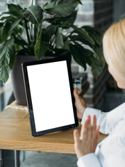 Online conference. Office woman. Digital mockup. Unrecognizable lady greeting somebody tablet computer with blank screen in light room interior.