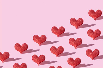 Pattern with red glitter heart shape on pink background with hard shadow. Valentines day...