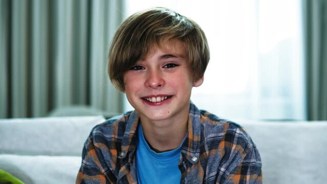 Happy smiling smiley teenage boy looking at camera. Portrait of Teenager boy indoors. Toothy child kid boy looking 