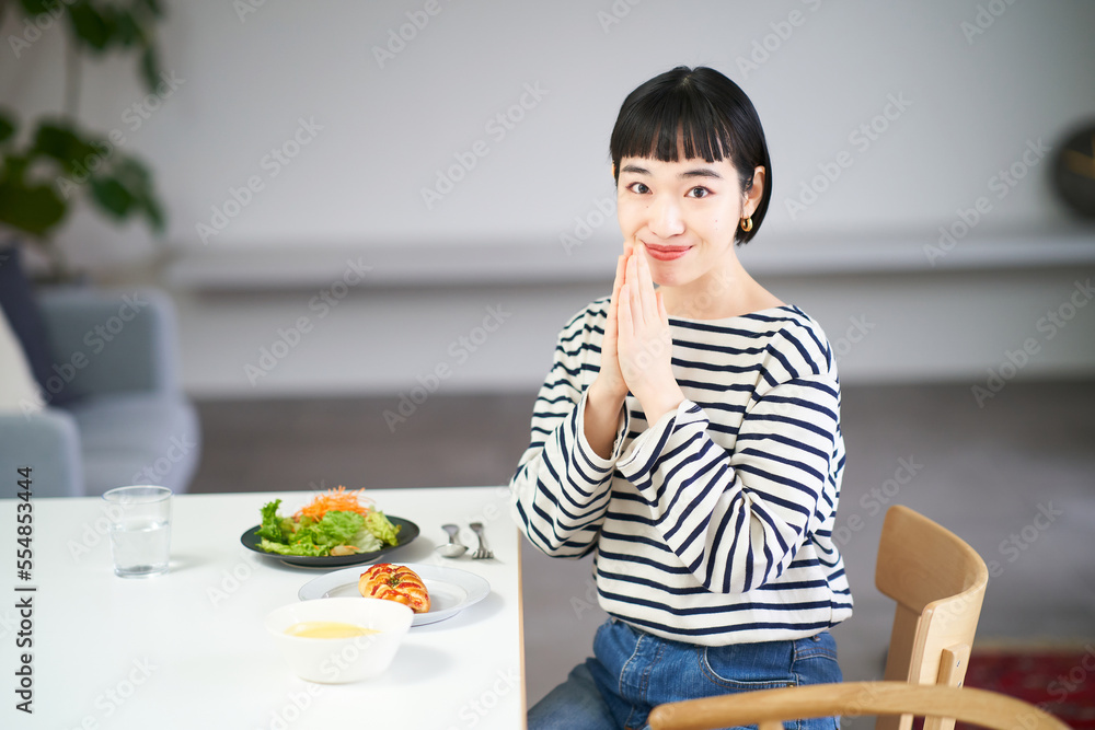 Poster 家のダイニングで食事を始める女性