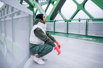 Young muslim woman having break during morning jogging.