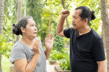 Fototapeta premium Angry old husband trying to punch his senior wife, concept of senior couple with regular fight and domestic violence