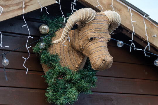 Stuffed bovine cow Christmas decoration display hanging on a wooden shed wall during the festive season celebrating the nativity of Jesus Christ, stock photo image