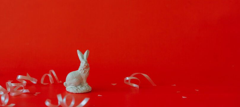 close up white rabbit model on red background with rolling ribbon and copy space for chinese happy new year celebrate 2023