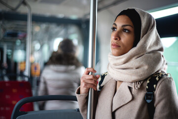 Young muslim woman traveling by public bus.