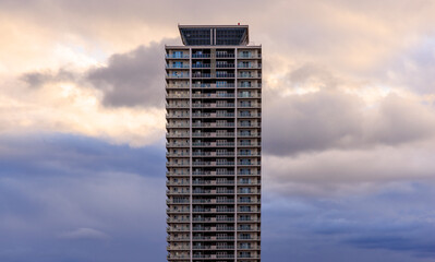 Dramatic clouds behind apartment tower at sunset
