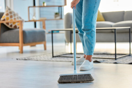 Cleaning, woman with broom and sweeping living room dirty floor and spring cleaning. Housekeeper, cleaner and housekeeping service or home maintenance for fresh, neat and dust free house or apartment