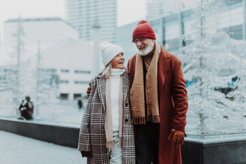 Senior couple walking in winter city center.